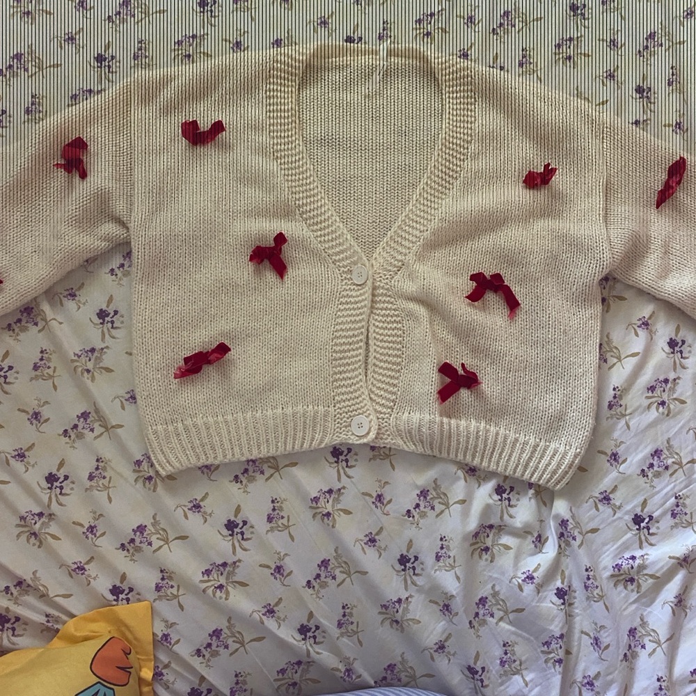 Winners cream cardigan with elegant red velvet bows. Great for the holidays.